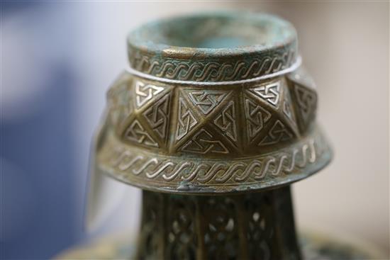 A 13th century Khorassan silver and copper inlaid bronze candlestick, H.10.5in.